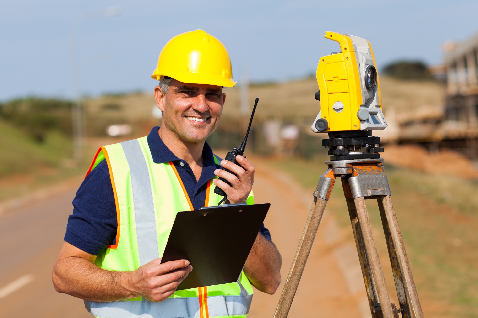 senior land surveyor working at road construction site